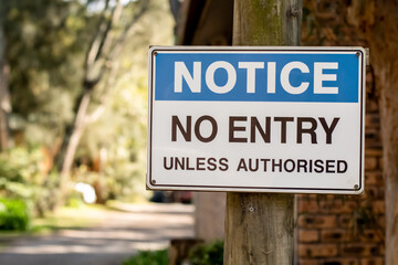 Notice. No entry unless authorised sign on a wooden pole