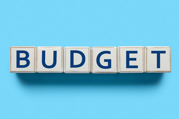 Word BUDGET made of cubes on light blue background