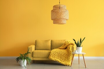 Sofa and table near yellow wall in living room