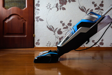 Modern vacuum cordless vacuum cleaner with water nozzle for cleaning floors. House cleaning.