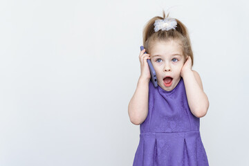 surprised and shocked little girl talking on the phone. place for text, copy space