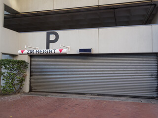 parking garage entrance with closed metal garage door and maximum height restriction sign to a...