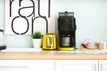 Modern coffee machine and toaster on table in kitchen