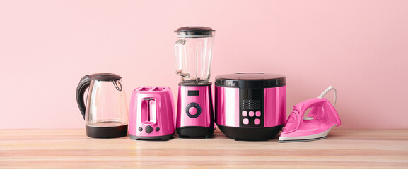 Different household appliances on table in room - obrazy, fototapety, plakaty