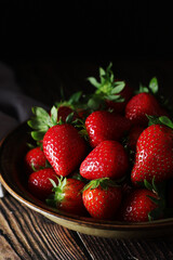 A bowl with ripe bright strawberry in rustic style