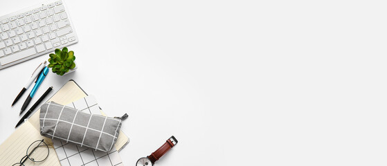 Pencil case, PC keyboard and stationery on light background with space for text