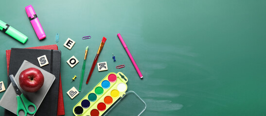 School stationery and apple on chalkboard with space for text