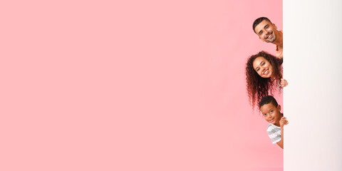 Happy interracial family with blank poster on pink background with space for text
