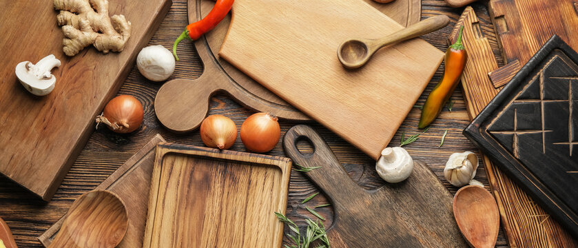 Many cutting boards with products on wooden background