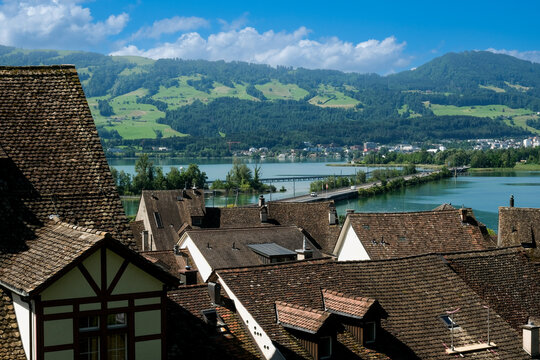 A picture of houses roof in Rapperswil old town with lake and bridge insight.