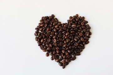 Heart from coffee beans. Textured background with robusta and arabica coffee beans closeup. Every day, people drink aromatic strong espresso in the morning. A popular world tradition in every country.