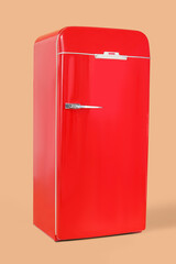 Stylish retro fridge on beige background