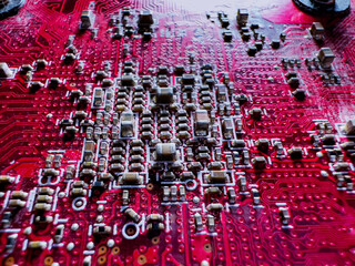 Close-up of transistors and chips on the red circuit board