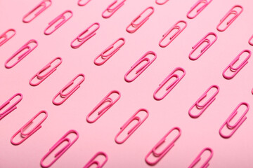 Pink paper clips on color background, closeup