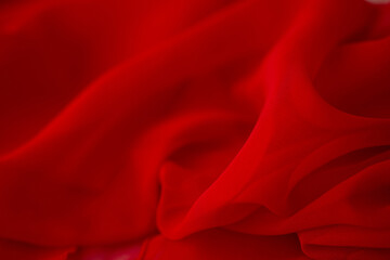 Red chiffon or silk material. Satin fabric close up background and texture with place for text....
