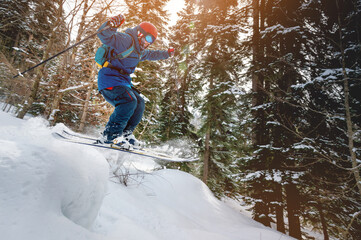 Fototapeta na wymiar good skiing man in the snowy mountains forest, good winter day, incredible ski jump