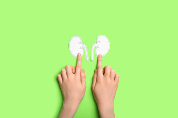 Woman with paper kidneys on green background