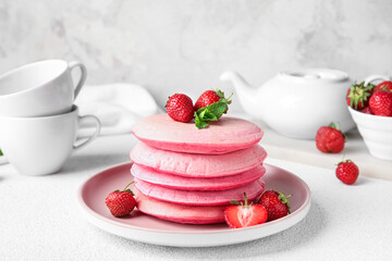 Plate of tasty pancakes with strawberry on light table