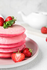 Plate of tasty pancakes with strawberry on table, closeup