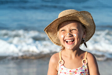 Sea Holiday Child Smiling with Sunscreen on Face on Sea Background. Сhildren Sunblock Cream for...