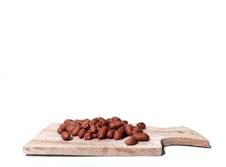 raw peanuts flat lay on a wooden cutting board . isolated on white background. food ingredients in the form of nuts on the kitchen