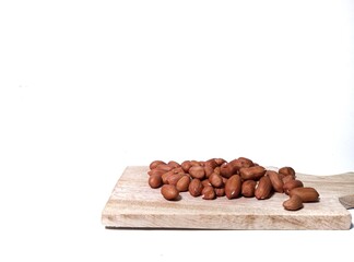 raw peanuts flat lay on a wooden cutting board . isolated on white background. food ingredients in the form of nuts on the kitchen
