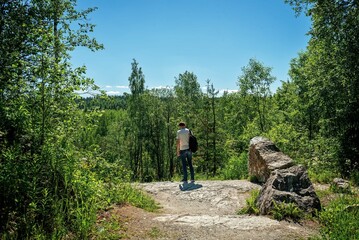 Male tourist stands on a mountain in a nature park in northern europe in finland