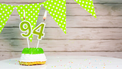 Beautiful festive background with the number  94 with a cake and lit candles, space saving for any...