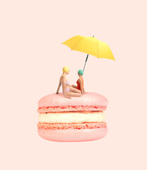 Contemporary art collage. Two girls in swimming suit sitting on delicious dessert, macaron under beach umbrella