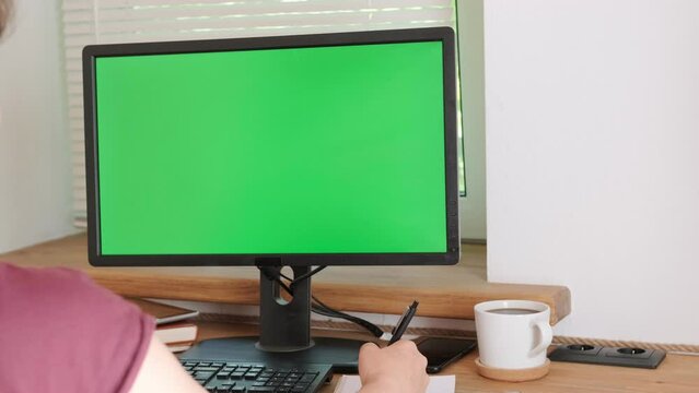 Corporate employee using computer with horizontal green screen for business project. Businesswoman looking at monitor with chroma key and isolated mockup template while using keyboard