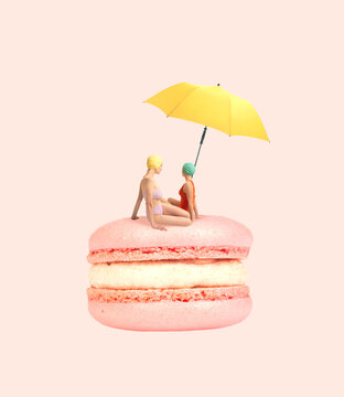 Naklejki Contemporary art collage. Two girls in swimming suit sitting on delicious dessert, macaron under beach umbrella
