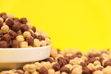 Corn sweet balls on a yellow background. Quick dry breakfasts, side view.