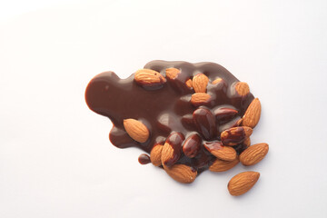 dark chocolate cream pouring on almond nut on white 