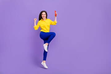 Fototapeta na wymiar Full length body size view of beautiful trendy cheery girl jumping using device dance isolated over bright violet purple color background