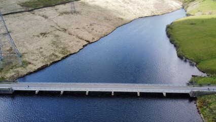 Aerial view looking down onto a road crossing a lake. Taken in Yorkshire England. 