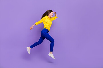 Fototapeta na wymiar Full length body size view of attractive cheery girl jumping looking copy space isolated over bright violet purple color background