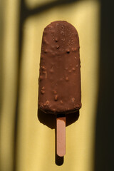 Chocolate Ice cream on wooden stick with shadows