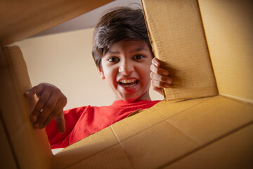 Portrait of boy opening a cardboard box