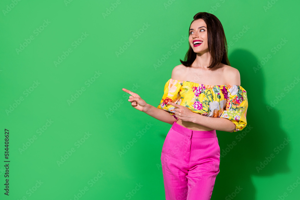 Wall mural photo of cheerful adorable person look direct fingers empty space isolated on green color background