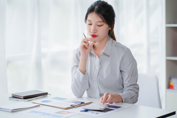 Young asian businesswoman beautiful charming smiling and talking on the mobile phone in the office