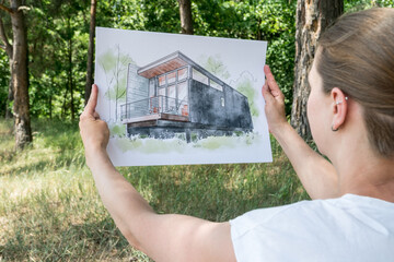 Contemporay house design hand drawn  sketch in architecht's hands.