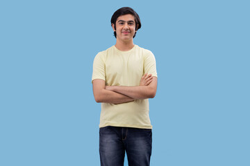 Portrait of a happy teenage boy standing against blue background