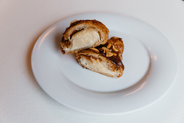 appetizing croissant with chocolate and peanuts on a plate