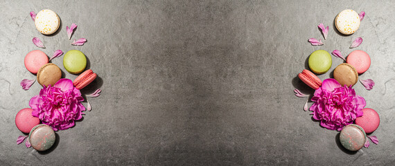 Macarons with peony flower on a stone background. Sweet dessert, colorful and pastel colors