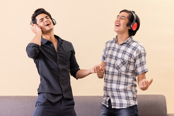Portrait of two happy teenage boys listening to music and gesturing