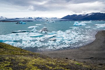 iceberg and floating blocks of ice in glacier lagoon - 514414081