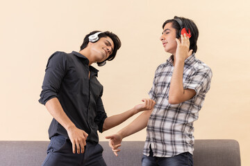 Portrait of two happy teenage boys listening to music and gesturing