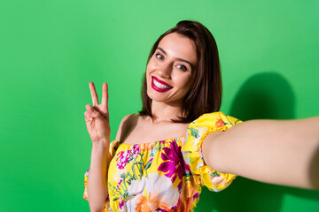 Photo of sweet adorable lady wear off shoulders blouse taking selfie showing v-sign isolated green...