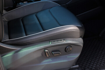 Obraz premium Detail of new modern car interior, Focus on seat adjust switch. The driver seat of a luxury business class car. Car seat manual adjust stick panel to control seat position in passenger car. 