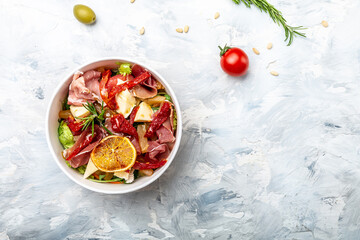 Healthy salad with Prosciutto, ham and grapefruit jamon, salad mix, grapefruit, cherry tomatoes, parmesan cheese. in plastic package for take away or food delivery. place for text, top view